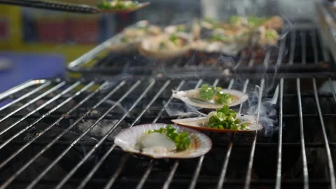 Grilled shellfish, bursting with garlic, green onions, and savory sauce, cook Stock Footage 307378516