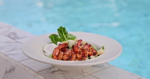 Grilled Shrimp Caesar Salad by Pool - Luxury Resort Dining Stock Footage 327026284