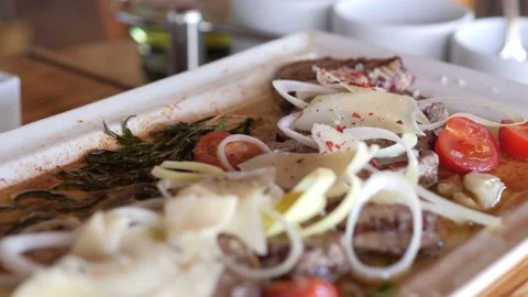 Grilled sliced Beef Steak with tomatoes, parmesan and rosemary on a plate, top Stock Footage 140973176