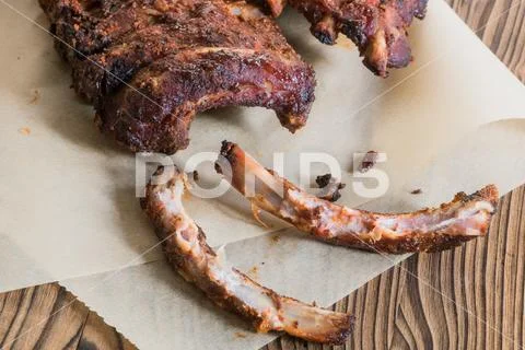 Grilled Spareribs with gnawed bones on backed paper Stock Photos