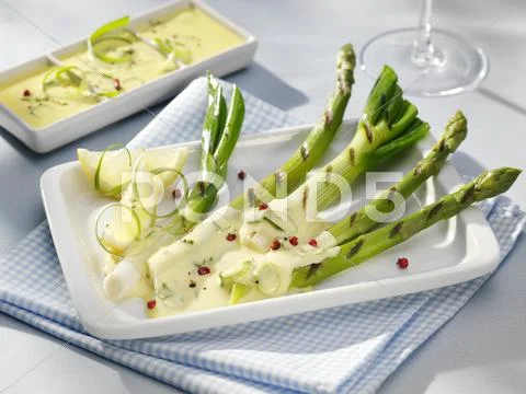 Grilled spring onions and asparagus with lemon butter sauce Stock Photos