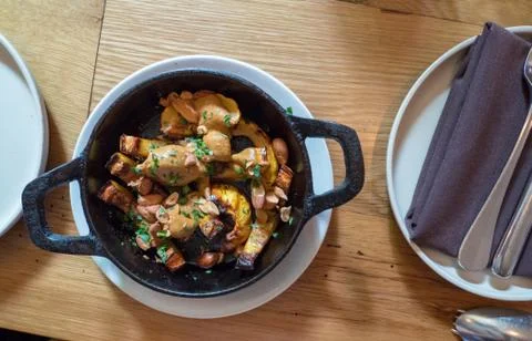 Grilled squash dish in small cast iron skillet next to napkins and plate Stock Photos