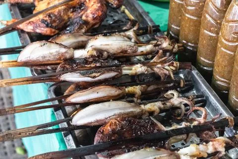 Grilled squid and chicken displayed on skewers at a cambodian market in phnom Stock Photos