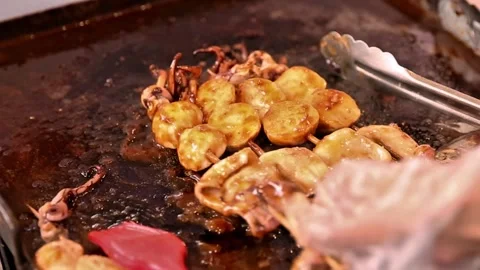 Grilled squid being seasoned using a brush Stock Footage 272298231