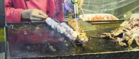 Grilled Squid Skewers on Flat Top Grill at Night Market Street Food Stall Stock-Footage 331979956