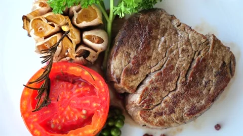 Grilled steak with fresh herbs served with roasted vegetables Stock-Footage 264243048