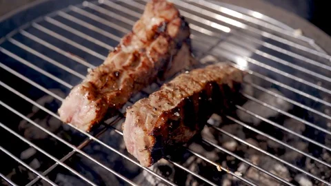 Grilled steak. Ribs on barbecue grill. Cooking pork ribs on grill on flame 動画素材 97750341