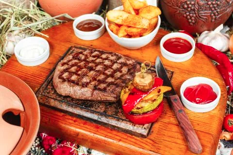 Grilled steak on rustic cutting board with rosemary and spices Stock Photos