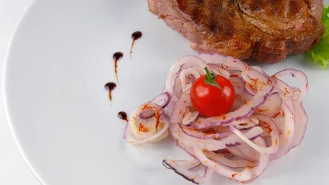 Grilled steak on a white plate with vegetables, main dish in Restaurant Stock Footage 79711062