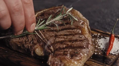 Grilled t-bone steak on a black board Stock Footage 113081684