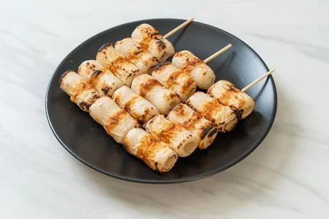 Grilled tube shaped fish paste cake skewe or tube squid skewer 写真素材