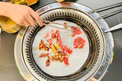 Grilling Assorted Meats on a Tabletop Barbecue Grill Stock-Fotos