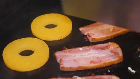 Grilling Bacon and Pineapple Rings on Flat Top Griddle Video stock 347687635