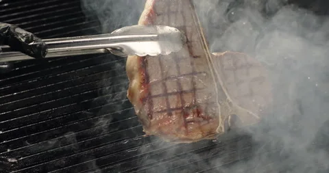 Grilling BBQ meat. Chef takes ready juicy steak off the barbecue grill. Smoke Stock Footage 275658954
