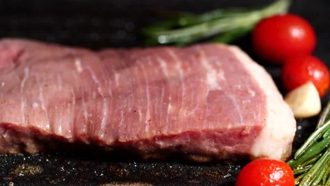 Grilling beef steak, meat steak with rosemary, tomatoes on hot iron plate Video stock 223882244