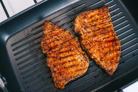 Grilling beef steak in a pan, close-up. Stock Photos