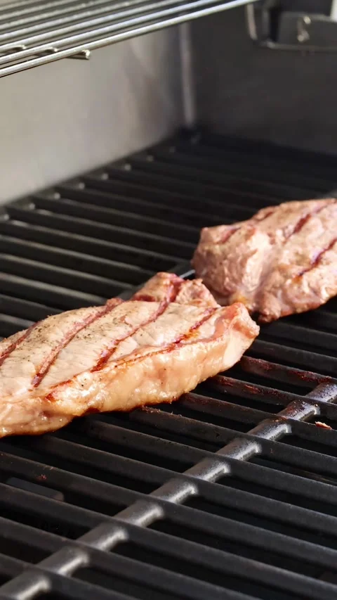 Grilling Beef Steaks on a Barbecue Grill 動画素材 310987237