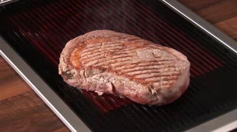 Grilling beefsteak on an electric grill Stock Footage 24633990