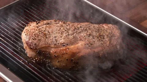 Grilling beefsteak on an electric grill Stock Footage 24634096