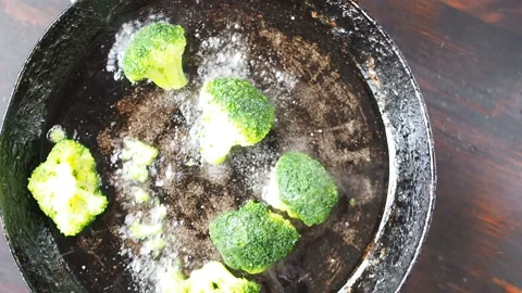 Grilling broccoli in a cast iron pan with beans and corn. slow motion Stock Footage 104270601
