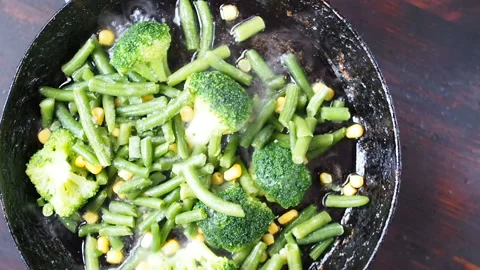 Grilling broccoli in a cast iron pan with beans and corn. slow motion Stock-Footage 104270736