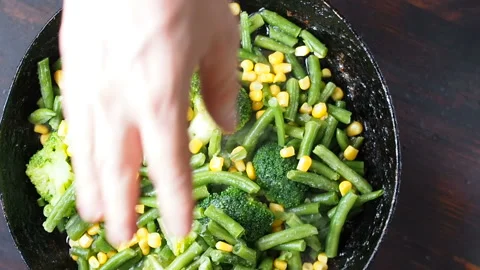 Grilling broccoli in a cast iron pan with beans and corn. slow motion 動画素材 104270896