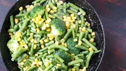 Grilling broccoli in a cast iron pan with beans and corn. slow motion 스톡 동영상 104271076