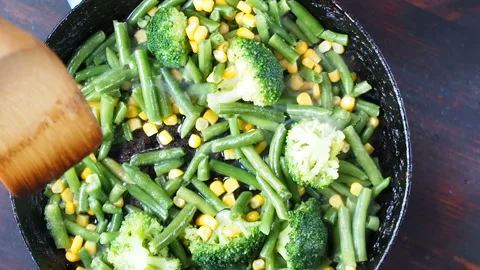 Grilling broccoli in a cast iron pan with beans and corn. slow motion Stock Footage 104271395