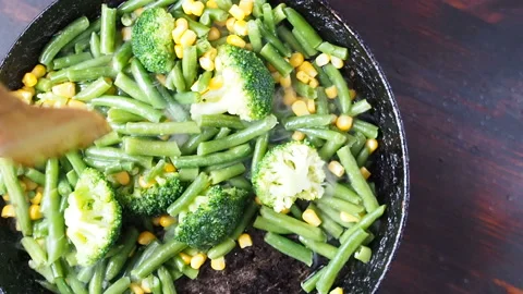 Grilling broccoli in a cast iron pan with beans and corn. slow motion Vídeos de archivo 104271478