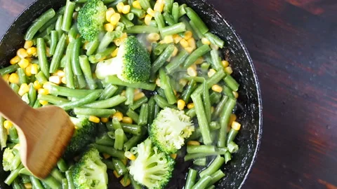 Grilling broccoli in a cast iron pan with beans and corn. slow motion Stock Footage 104271543