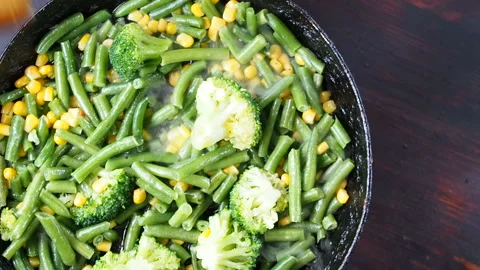 Grilling broccoli in a cast iron pan with beans and corn. slow motion Vídeos de archivo 104271641