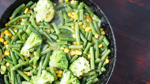 Grilling broccoli in a cast iron pan with beans and corn. slow motion 库存影片 104272005