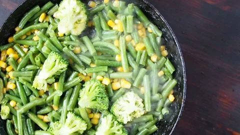 Grilling broccoli in a cast iron pan with beans and corn. slow motion Vídeos de archivo 104272457