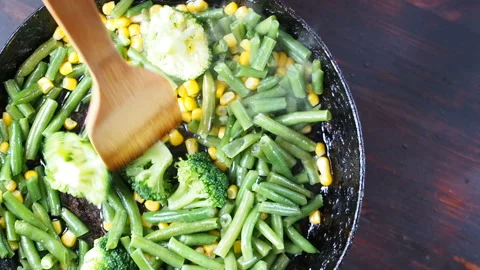 Grilling broccoli in a cast iron pan with beans and corn. slow motion Stock-Footage 104272874