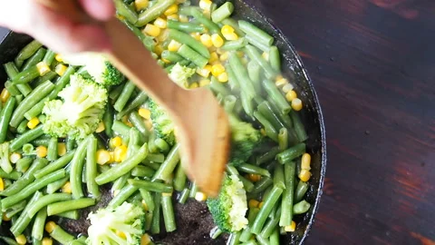 Grilling broccoli in a cast iron pan with beans and corn. slow motion 動画素材 104273009