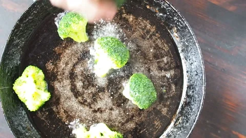 Grilling broccoli in a cast iron pan with beans and corn. slow motion Video stock 104273266