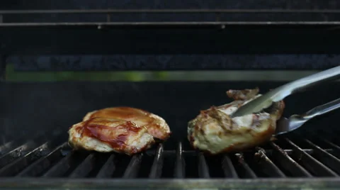 Grilling chicken, flip over, baste with BBQ sauce on a hot grill Stock Footage 39824894