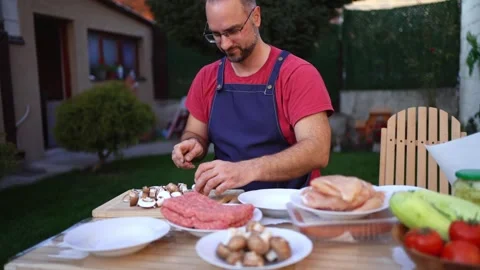 Grilling delicious meals in a cozy backyard setting with fresh ingredients and Stock Footage 309928547