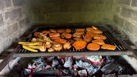 Grilling a dish of meat and vegetables on a brick fireplace Stock Footage 267262249