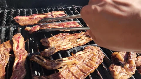 Grilling korean sauce marinated beef ribs in a sunny day Stock Footage 200865381