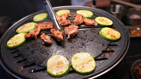 Grilling Meat and Vegetables on a Hot Plate with Tongs in a Restaurant Settin Vídeos de archivo 337696112