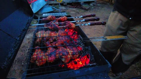 Grilling meat at a campsite during sunset near a forest with friends on a summer Video stock 332065714