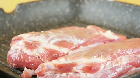 Grilling meat on a cast iron grill pan for flavorful dishes Stock Footage 325038033