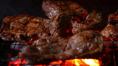 Grilling meat on hot fire flame of slow motion in camping on night Stock Footage 228822573