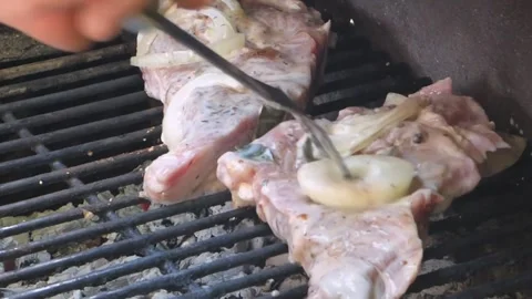 Grilling meat with onion slices in a backyard setting 스톡 동영상 320198728