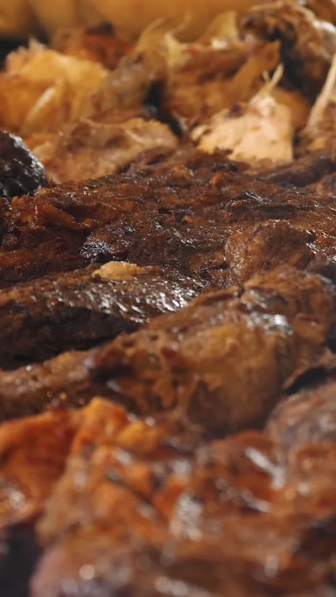 Grilling meat over burning coals. close-up. large pieces of pork roasting on bbq Video stock 313236902