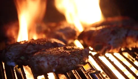 Grilling meat over a roaring fire in a backyard setting Stock Footage 320198721