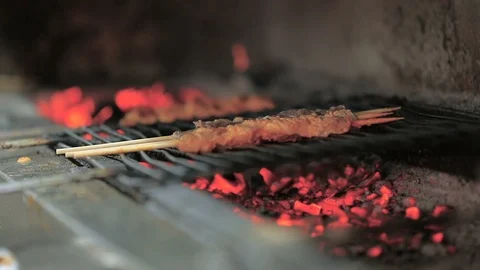 Grilling meats on coal, fire flames in back Stock Footage 122065608