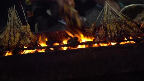 Grilling process of Indonesian satay or skewered chicken meat , Stock Footage 211791614