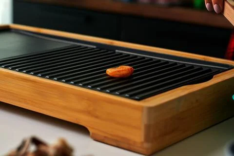 Grilling process with a single apricot slice on a bamboo grill, showcasing culin Stock Photos